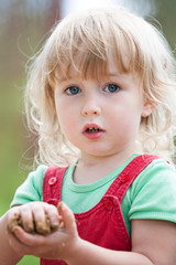 cute two years old blonde white girl face closeup view on summer outdoor background