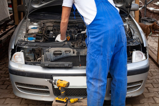 mechanic men with wrench repairing car engine at