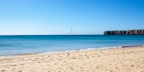Velero fondeado junto a la playa de Sagres, Algarve (Portugal)