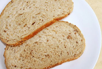Two slices of whole grain bread on a white plate