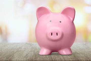 Piggy bank in glasses on background