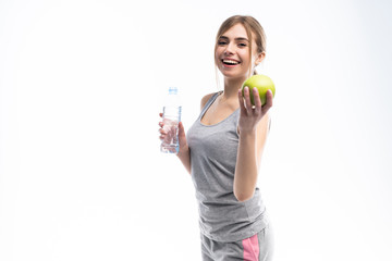 Portrait of young attractive woman with green apple and bottle. Dieting concept. Isolated on white