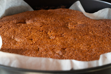 freshly baked cake with a beautiful Golden crust in a black baking form as a background