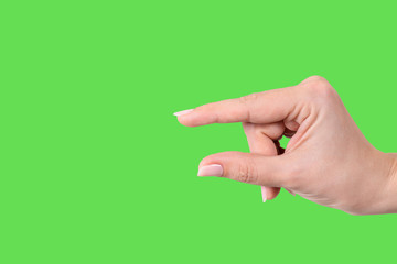Closeup view of female hand forming gesture Little bit. Isolated on bright green chroma key background. Horizontal color photography.