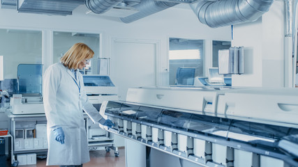 In Laboratory Female Scientist Inspects Medical Equipment Analyzing Test Tube with Blood Samples....