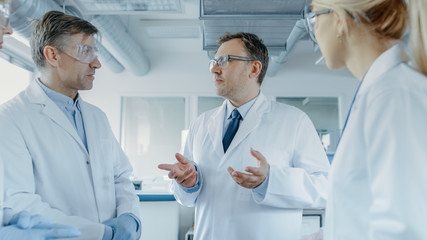 Team of Research Scientists Have Meeting, They Have Discussion While Standing in the Middle of...