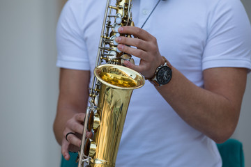 hands of the musician play the saxophone
