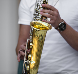 hands of the musician play the saxophone