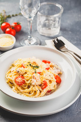 Delicious salmon linguine pasta dish with herbs and grilled salmon filet.