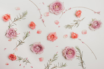 Fototapeta premium Flower composition. Pink roses and green branches on a white background. Pastel photography, flat, top view