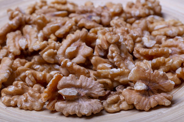 Walnuts on the wooden plate on the table