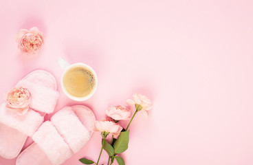 Composition of faux fur woman slippers, flowers and black coffee on a light pink background. Morning concept. Flat Lay. Top View