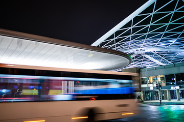 Tilburg, Noord Brabant, Netherlands - april 2 2019: A bus driving next to the bus station and train station. This is the new public transport hub in Tilburg. Seen at night.