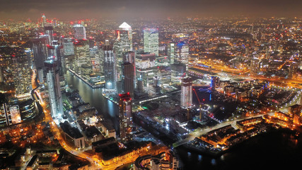 Aerial drone night shot from iconic Canary Wharf illuminated skyscrapers business and financial...