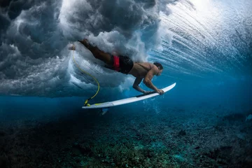 Poster Surfer dives under the breaking wave in the tropics © Dudarev Mikhail