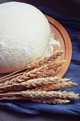 The batter and ears of corn on a wooden Board.