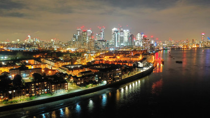 Fototapeta na wymiar Aerial drone night shot from iconic Canary Wharf illuminated skyscrapers business and financial area, Docklands, Isle of Dogs, London, United Kingdom