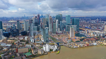 Plakat Aerial drone shot from iconic Canary Wharf skyscraper business and financial area with lots of clouds, Docklands, Isle of Dogs, London, United Kingdom