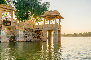 Central island park with sandstone buildings and trees growing at gadi sagar jaisalmer