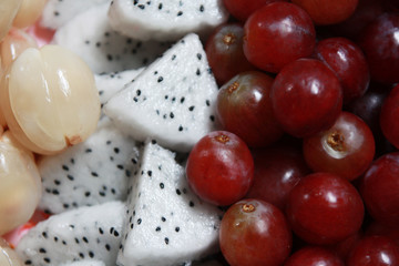 Fresh tropical fruits Dragon fruit, Red grapes and Wollongong in natural sunlight.