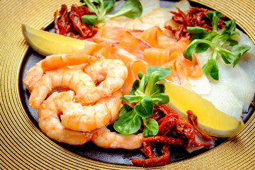 cooked shrimp on plate with seafood and dried tomatoes