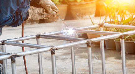 The welder is welding the steel frame. Labor and industrial work hard.