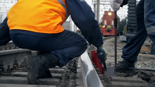 Repairmen on railway tracks. Railway workers stands on freight station and repair the railway 