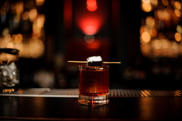 Brownie piece on the skewer with a powdered sugar on the cocktail glass