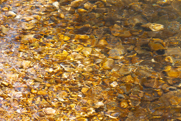 The reflection of the water surface with natural brown stones on the bottom is a lot of background.soft focus.