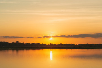 Sunset in the lake. beautiful sunset behind the clouds above the over lake landscape background. dramatic sky with cloud at sunset