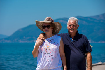 senior couple hugging while walking  by the sea