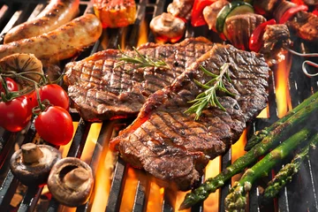 Fotobehang Heerlijk gegrild vlees met groenten sissend over de kolen op de barbecue © Alexander Raths