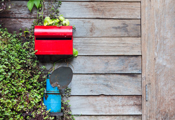 red mailbox on wooden house wall with leaf - 259911007