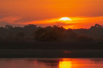 Sunset in the lake. beautiful sunset behind the clouds above the over lake landscape background. dramatic sky with cloud at sunset