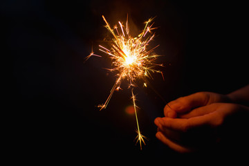 Woman hand holding a burning sparkler