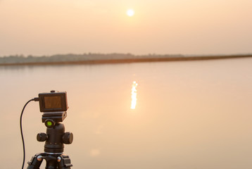 Take pictures sunset at the river with Action camera on tripod