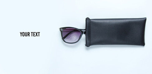Sunglasses with protective leather case on gray background. Copy space.
