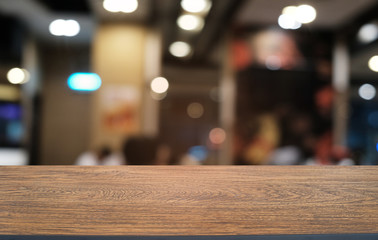 Empty dark wooden table in front of abstract blurred bokeh background of restaurant . can be used for display or montage your products.Mock up for space.