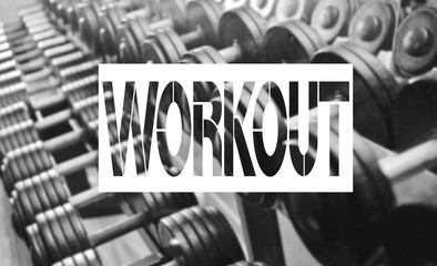 Word training on background of blur metal dumbbells rack . Black dumbbell set.