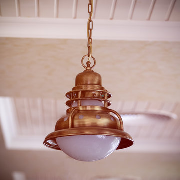 vintage bronze chandelier suspended from the ceiling by a metal chain