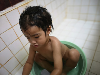 The boy is taking a bath by himself.