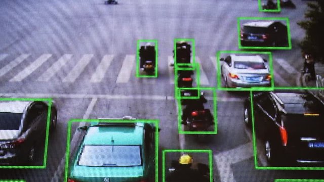 CCTV camera. Real-time tracking of vehicles and people on the street. Authentic pixelated image from a real monitor.