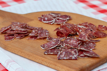 slicing a variety of sausages on a wooden board