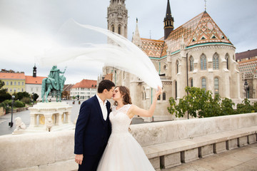 Young beautiful stylish pair of newlyweds kissing by the Fisherman's Bastion in Budapest, Hungary