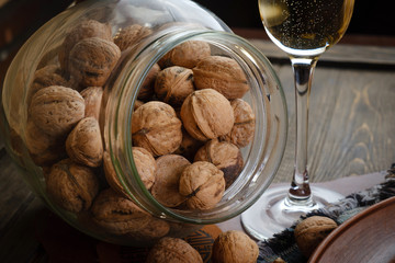 Glass jar with walnuts on wooden table. Healthy tasty organic food concept