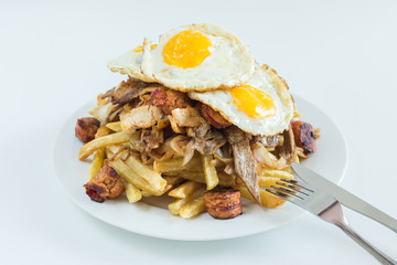 Chorrillana, french fries, fried onion, sausages and fried eggs with white background