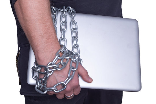 a person holds a laptop that is tied to a hand with a metal chain, dependence on computer games and technologies