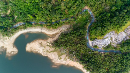 Top down from Drone aerial view of rainforest with asphalt road around the dam