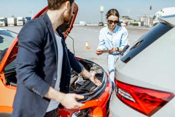 Naklejka premium Two drivers inspecting car damage after the traffic accident on the city road