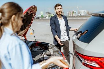 Two drivers inspecting car damage after the traffic accident on the city road